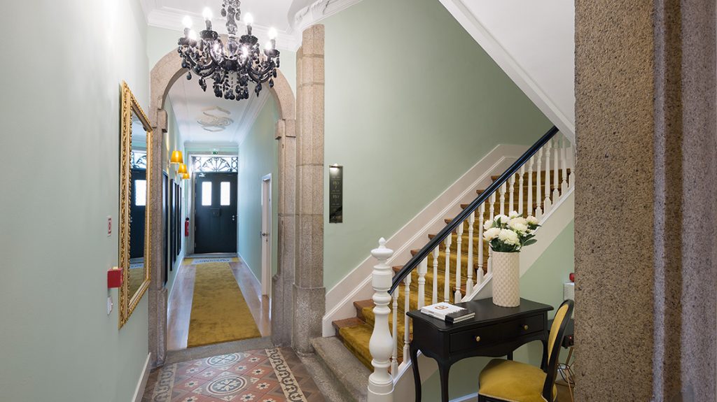 Hall com lustre e escadaria de madeira